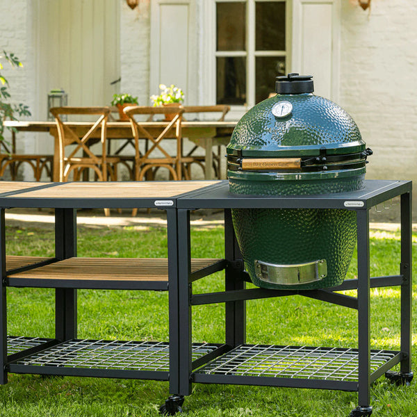 Green barbecue grill on a stand outdoors with a patio in the background